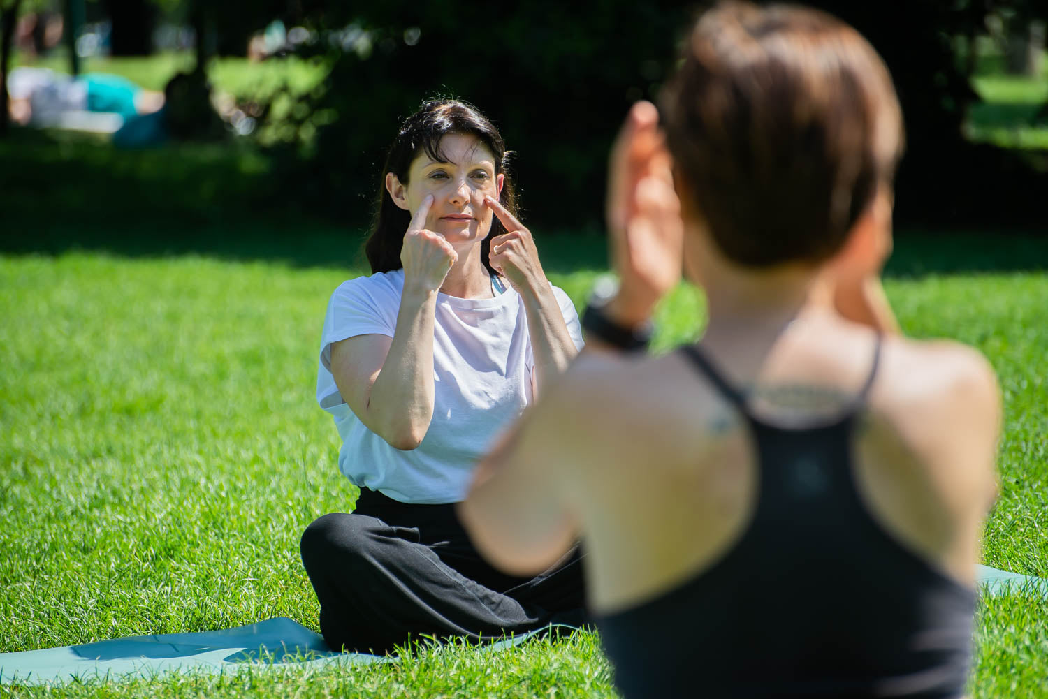 Insegnante di Yoga Facciale che insegna ad un corso one to one per insegnanti di yoga facciale al parco 